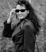 woman wearing sunglasses  and business suit, walking outside